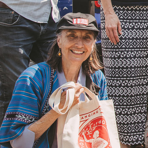 Woman with a colorful shirt wearing the Equal Exchange hat