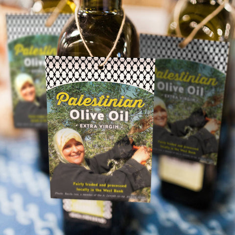 hang tags on olive oil bottles featuring a black and white keffiyeh pattern and photo of woman harvesting olives with text that says Palestinian Olive Oil