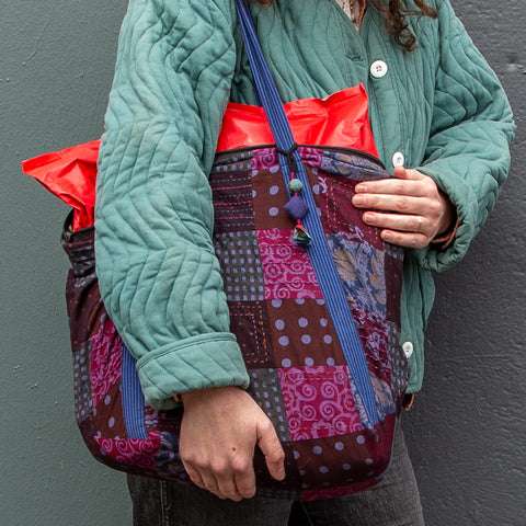 Patchwork Carryall tote worn over the shoulder of a person in a green jacket
