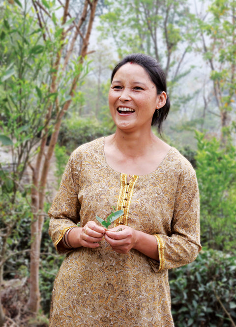 Mineral Springs tea co-op member on her land holding a tea bud