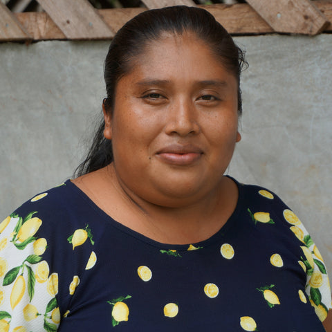 Nilka Sanchez, member of COCABO co-op in Panama, in front of a cement wall