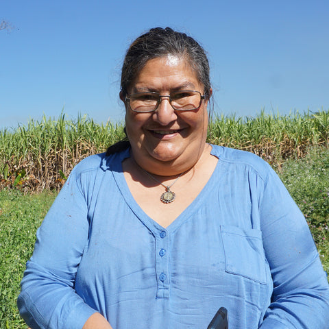 Cristina Benitez standing in front of sugar cane