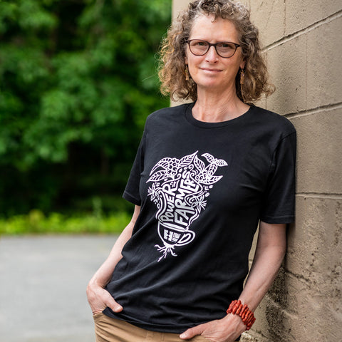 Woman wearing a black T-shirt with 'Power to the Farmers' written on it