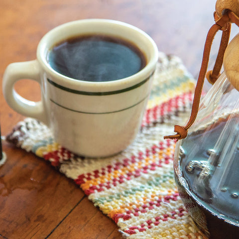 steaming mug of Congo Coffee with carafe