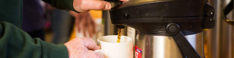 Man pumping coffee from thermos
