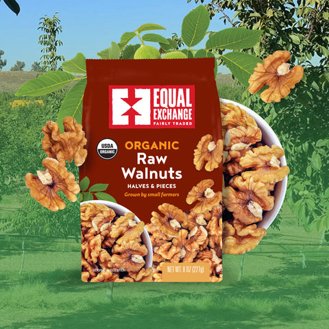 A bag of Equal Exchange Organic Raw Walnuts halves and pieces, shown in front of a blurred outdoor walnut grove scene with bowls of walnuts.