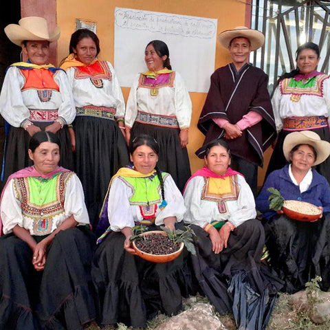 Women farmers of Norandino with baskets of unroasted coffee beans in traditional dress