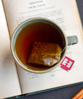 Tea cup with a tea bag on an open book