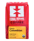 A 12 oz bag of Equal Exchange Organic Colombian coffee, featuring a bright red packaging design with a white logo and a yellow label at the bottom.