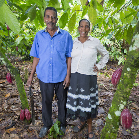 Cacao farmers and members of CONACADO co-op, José Hilario Mosquea and Elsa García stand together next to their cacao trees on their farm in the Dominican Republic