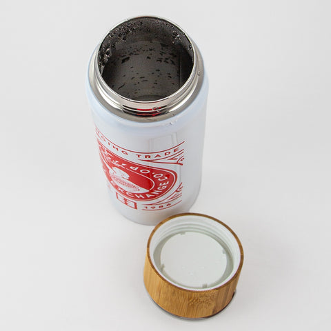 Top down view of open insulated steel tumbler with bamboo and plastic cap