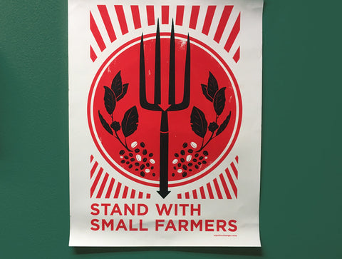 Red and white graphic poster that says stand with small farmers on a green wall