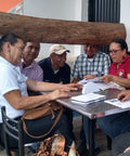 Group of people sitting around a table with documents and notebooks.