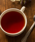 Cup of brewed Organic Black Tea sitting on a table with spoon