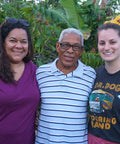 Two Equal Exchange employees, Jackie Rhone and Megan Chisholm, standing next to Noberto Frias, a cacao farmer and member of CONACADO co-op in the Dominican Republic