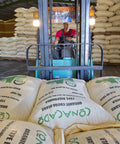 Driving burlap bags of cacao beans around a warehouse at CONACADO cooperative