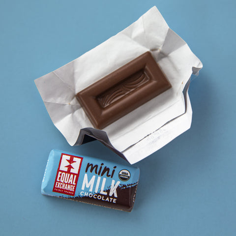 One unwrapped Milk Chocolate mini with one wrapped milk chocolate mini on a blue background