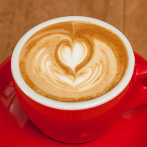 machiatto in a red espresso cup with heart shaped latte art