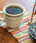 steaming mug of Congo Coffee with carafe