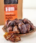 Bowl of Palestinian Medjool Dates in front of a box of the same